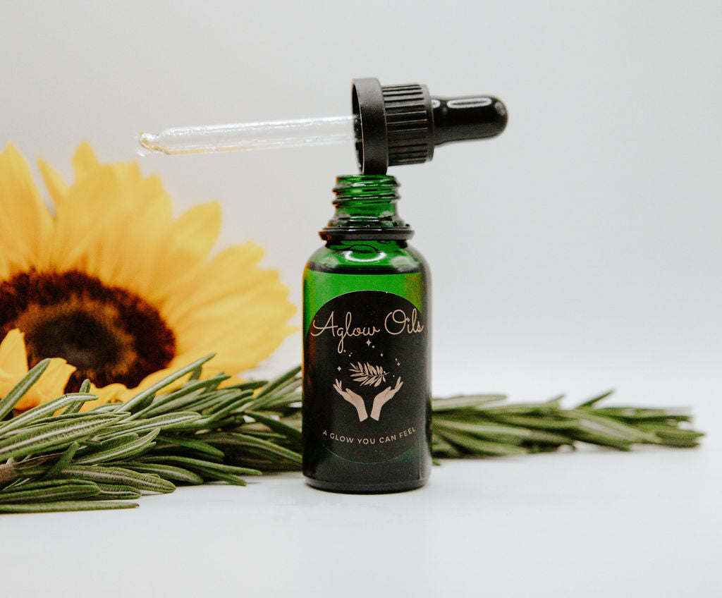 Green bottle with dropper, rosemary, and sunflower